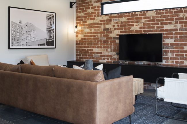 Cayman 287 living room with brick feature wall and leather couches