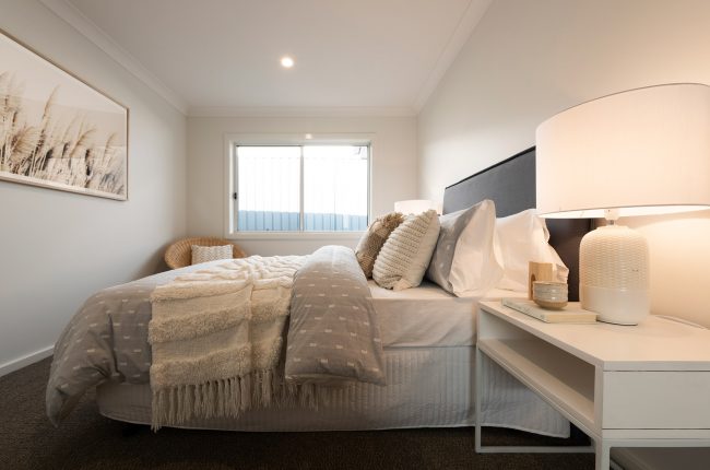 Noosa 223 bedroom with piles of blankets and pillows