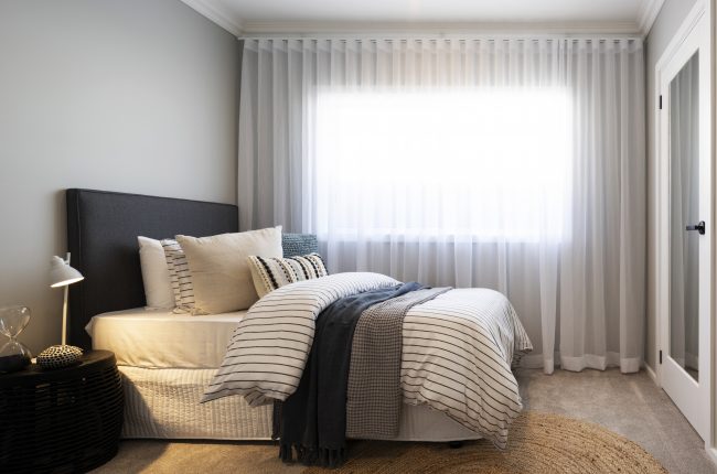 Avoca 210 bedroom with piled blankets and pillows